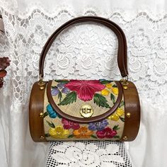 ✨Details: vintage 60s colorful floral raffia straw barrel style bag with wooden ends. Features gold metal turn clasp closure and hardware.  Brand: Bags by Whidby ✨Sizing: Body of purse measures approximately 10.25" wide and 6.5" tall. Total height including handle is 14".  ✨Condition: Great vintage condition with no major defects overall; has a couple minor imperfections such as small scratches on wood end and one of the gold studs is missing from the back (not very noticeable) See last photo for close ups Vintage Satchel Bag With Bamboo Handle, Vintage Summer Shoulder Bag, Handmade Vintage Straw Bag, Vintage Natural Bucket Shoulder Bag, Vintage Natural Straw Bag, Vintage Straw Bag For Daily Use, Vintage Brown Shoulder Bag With Bamboo Handle, Vintage Brown Bags For Spring, Vintage Brown Shoulder Bag For Spring