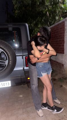 two people hugging each other in front of a truck