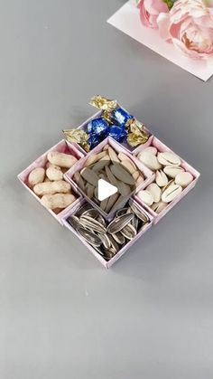 a box filled with assorted candies next to a bouquet of flowers and a card