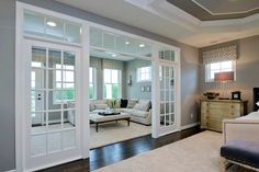 a living room filled with furniture and lots of glass doors to walk in the door