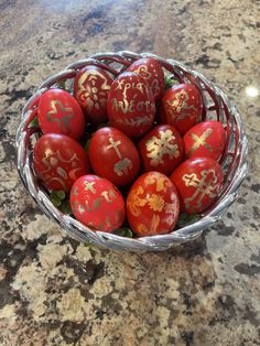 a basket filled with red eggs on top of a marble countertop covered in chinese writing