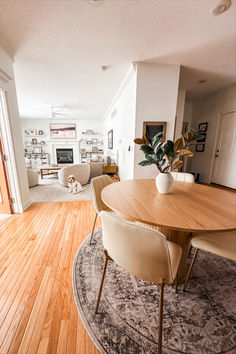 a dining room table with chairs and a rug on the floor in front of it