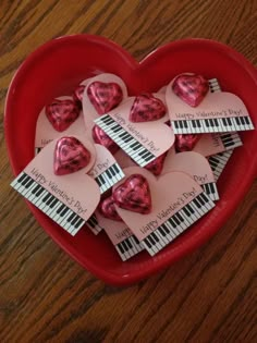 valentine's day candy hearts in a heart shaped bowl with piano keys on them