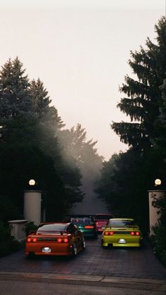 several cars parked on the side of a road in front of some trees and bushes