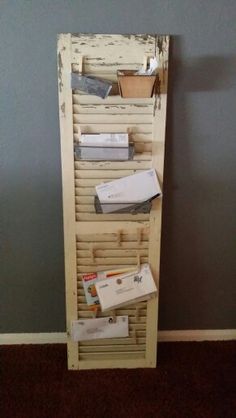 a book shelf made out of an old door with mail and boxes on the bottom