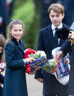 the young children are holding flowers and stuffed animals as they stand next to each other