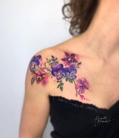 a woman's shoulder with purple flowers on it