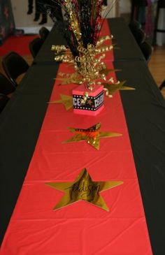 the table is decorated with red, black and gold ribbons and star centerpieces