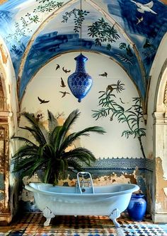 a bathtub in the middle of a room with blue and white tiles on the walls