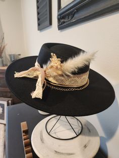 Custom Boho inspired Bolero/ Boater style wide brim  Fedora Black felt with dark taupe chiffon, wide ivory crochet ribbon, natural leather trim, rose gold chain with dried boho flowers. OS fits most, adjustable hat band. Hat has removable bands. These hats come in one size, they have an adjuster inside the crown to cinch them smaller.  We will include two foam reducing tape hat sizers to assist for a proper fit. Exact fit is not guaranteed or implied.  PLEASE make sure you are certain of your purchase before ordering. Because of various sanitary concerns, hats are NOT returnable or exchangeable. Luxury Black Hat Bands For Summer, Bohemian Hats For Spring Parties, Bohemian Style Adjustable Hats For Party, Bohemian Fitted Party Hats, Bohemian Short Brim Party Hats, Bohemian Party Hat With Short Brim, Bohemian Brimmed Hat For Parties, Bohemian Brimmed Party Hat, Bohemian Party Hats With Short Brim