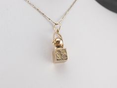 A lady is never without her signature scent! This vintage charm features a classic perfume bottle, and would be the perfect gift for the glamour girl in your life! This pendant does not come with the chain shown. Please feel free to contact us, we will help you find the perfect chain for your style and budget! Metal: 14K Yellow Gold Measures: 10 x 31 mm, with bail Vintage Necklace With Logo Charm For Formal Occasions, Elegant Vintage Charm Necklace For Keepsakes, Vintage Necklace With Logo Charm As Gift, Elegant Vintage Charm Necklace For Memorial, Yellow Gold Charm Necklace With Vintage Charm, Gold-tone Vintage Charm Necklace For Gift, Vintage Yellow Gold Locket Charm Necklaces, Luxury Gold Charms With Vintage Charm, Yellow Gold Vintage Charm