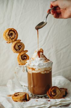 someone is dipping cinnamon rolls into a cup of hot chocolate