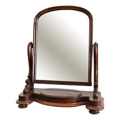 a wooden vanity with a mirror on it's top and an ornate stand underneath the mirror