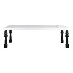 a white table with two black legs and an acrylic top on the bottom