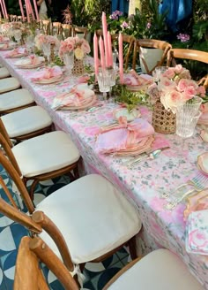 a long table is set with pink flowers and candles