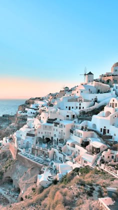 white buildings on the side of a hill near the ocean