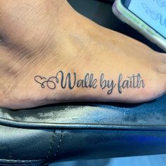 a foot with the words walk by faith on it