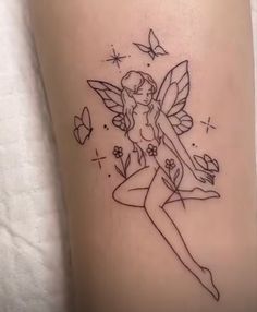 a small tattoo with a fairy on the side of her leg and butterflies flying around