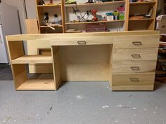 an unfinished desk with shelves and drawers