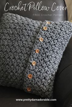 the crochet pillow cover is made with two buttons and sits on a black leather chair