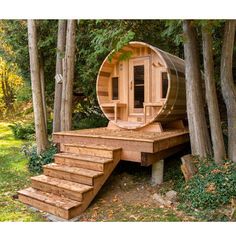 an outdoor sauna in the woods with steps leading up to it