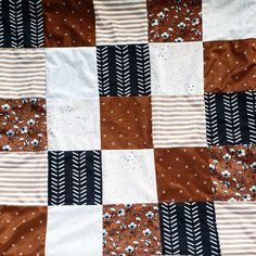 a patchwork quilt with black, white and brown designs on it's sides