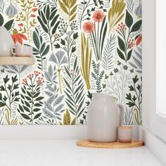 the wallpaper in this kitchen is painted with flowers and leaves, while other plants are on