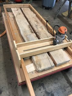 a machine that is sitting on top of some wooden planks in a room with other tools