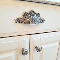 a close up of a cabinet with knobs and handles on the door, in a kitchen