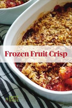 two white bowls filled with fruit crisp on top of a striped table cloth next to each other