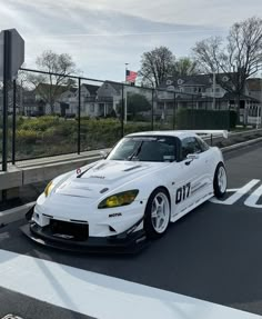 a white sports car is parked on the street