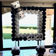 a balloon arch with the word boss on it in front of a large open window