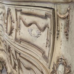 an ornately decorated sideboard is shown in white and grey tones with gold accents