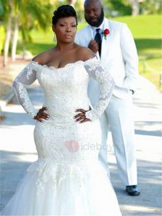 a woman in a wedding dress standing next to a man