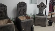 three cement tombstones with crosses on them sitting in front of a white wall and door