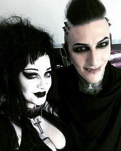 two people dressed in black and white posing for the camera with makeup on their faces