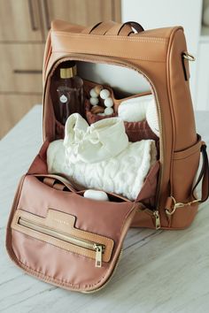 an open brown purse sitting on top of a table next to bottles and other items