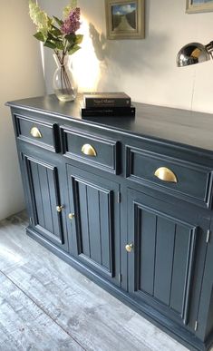 a blue sideboard with brass handles and knobs in a living room or dining room