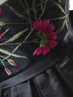 the back of a dress with flowers embroidered on it