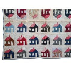 a quilted wall hanging with houses on it