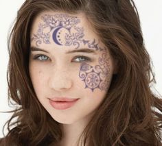 a woman with her face painted like the moon and stars