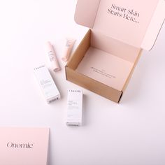 an open box with some skin care products in it on a white surface next to other items