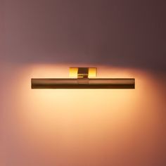 a light that is on the side of a wall in a room with pink walls