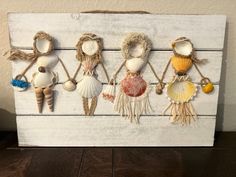 a group of seashells hanging on a wooden board