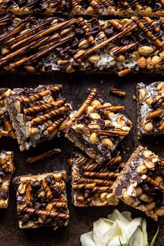 there are many pieces of chocolate and nuts on the table next to some white flowers