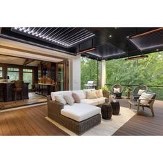 an outdoor living room with wood floors and white furniture