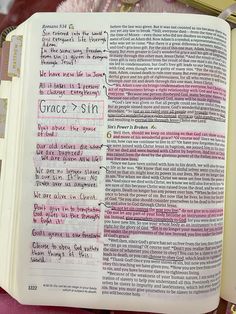 an open bible with the words grace and sin written in pink ink on top of it