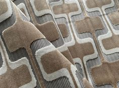 a close up view of the fabric on a bed with brown and white patterning