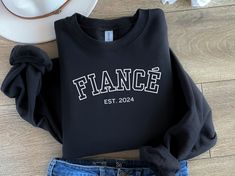 a black sweatshirt with the word france on it next to jeans and a cowboy hat