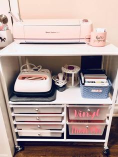 a sewing machine sitting on top of a white shelf next to drawers and bins